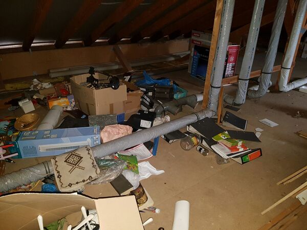 Dachboden mit herumliegenden Kartons, Aktenordnern und Haushaltsgegenständen im Chaos.
