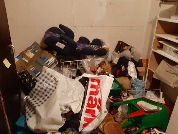 Abstellraum voller Kartons, Plastiktüten, Regalen und verschiedenem Haushaltskram.